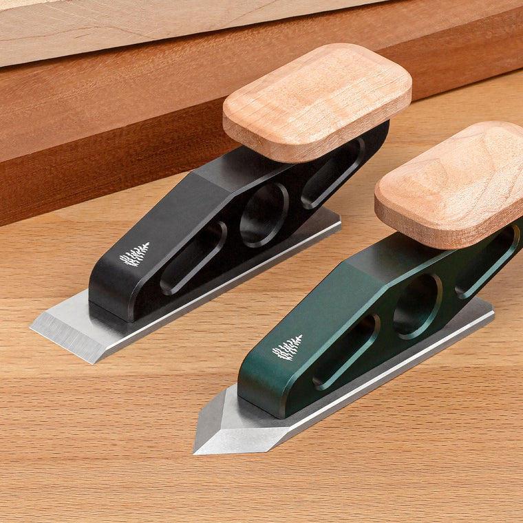  Two Optima Chisel Planes showing the two body colors (black and green) and both available blade irons (Flat and Spearpoint).