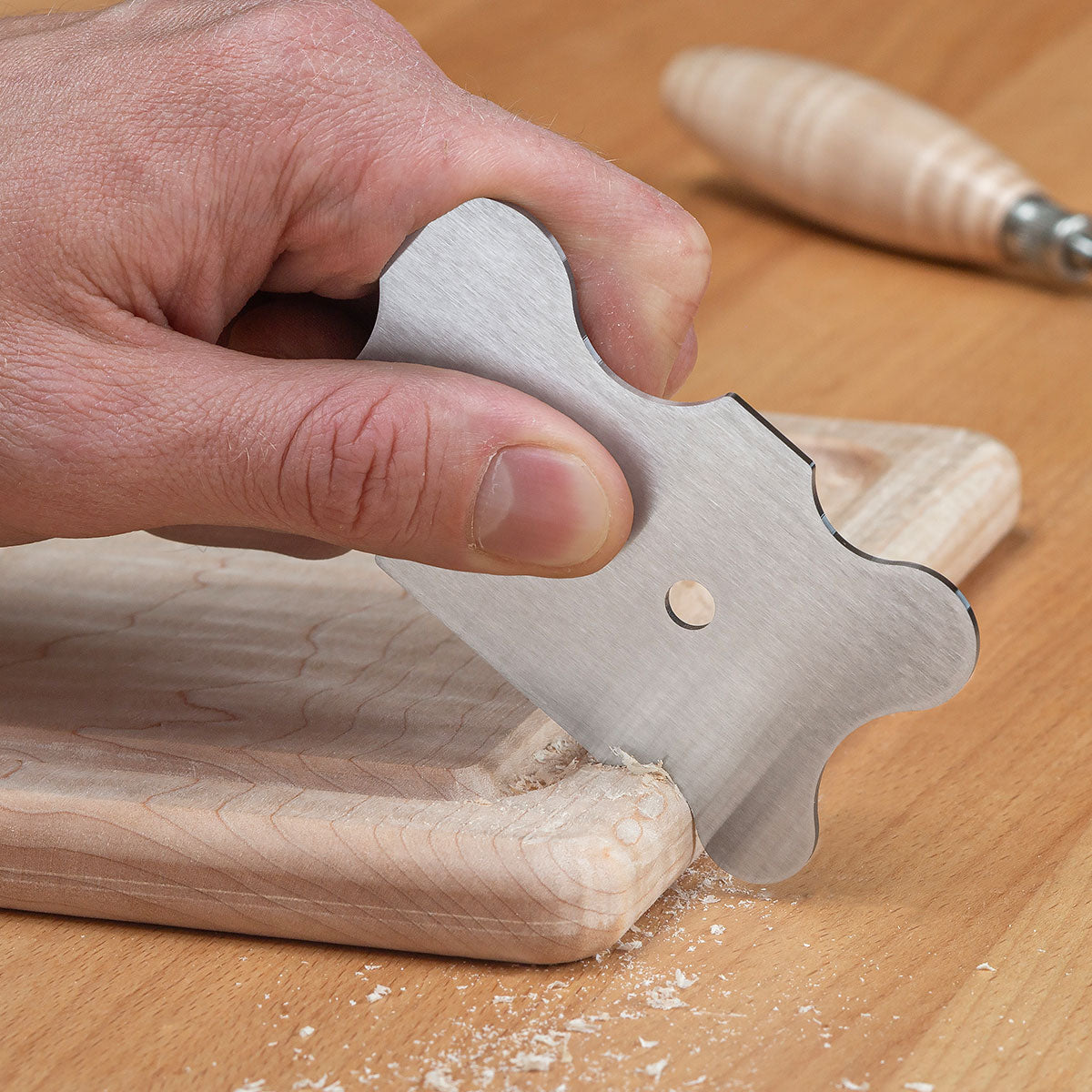The large Contoured Card Scraper being used to clean a round-over.