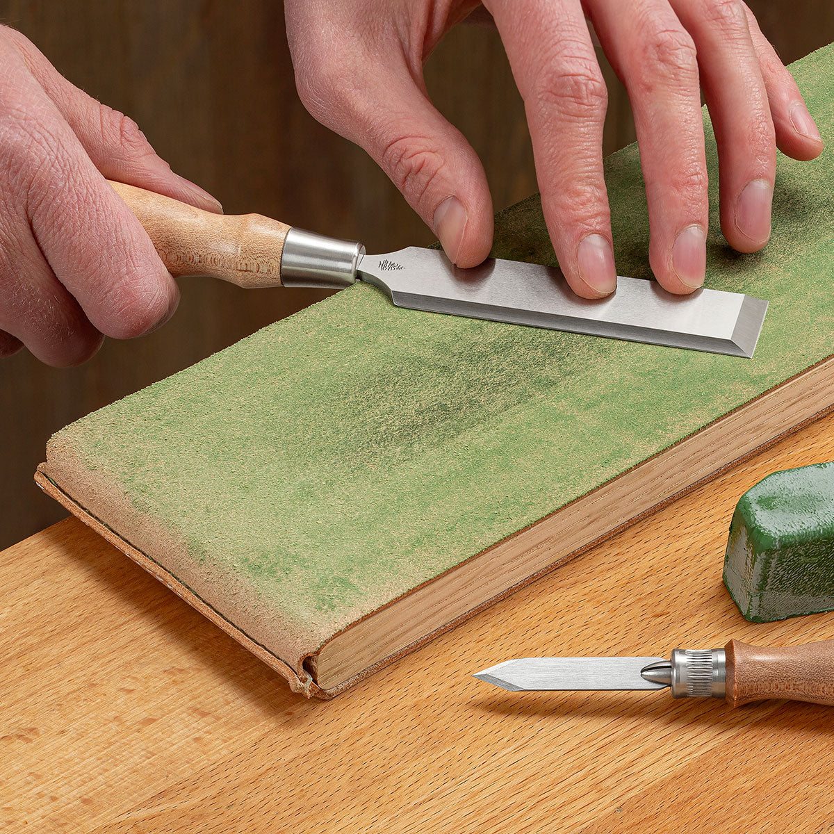 Pulling the blade of a Blue Spruce Chisel at a 45° angle to remove any remnants of a burr.