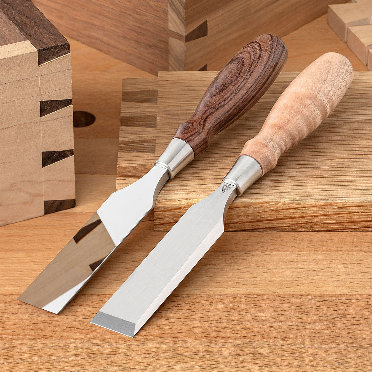 Two Blue Spruce Bench Chisels with 1” blades. Bolivian Rosewood handle on the left and a resin-infused Curly Maple handle on the right.