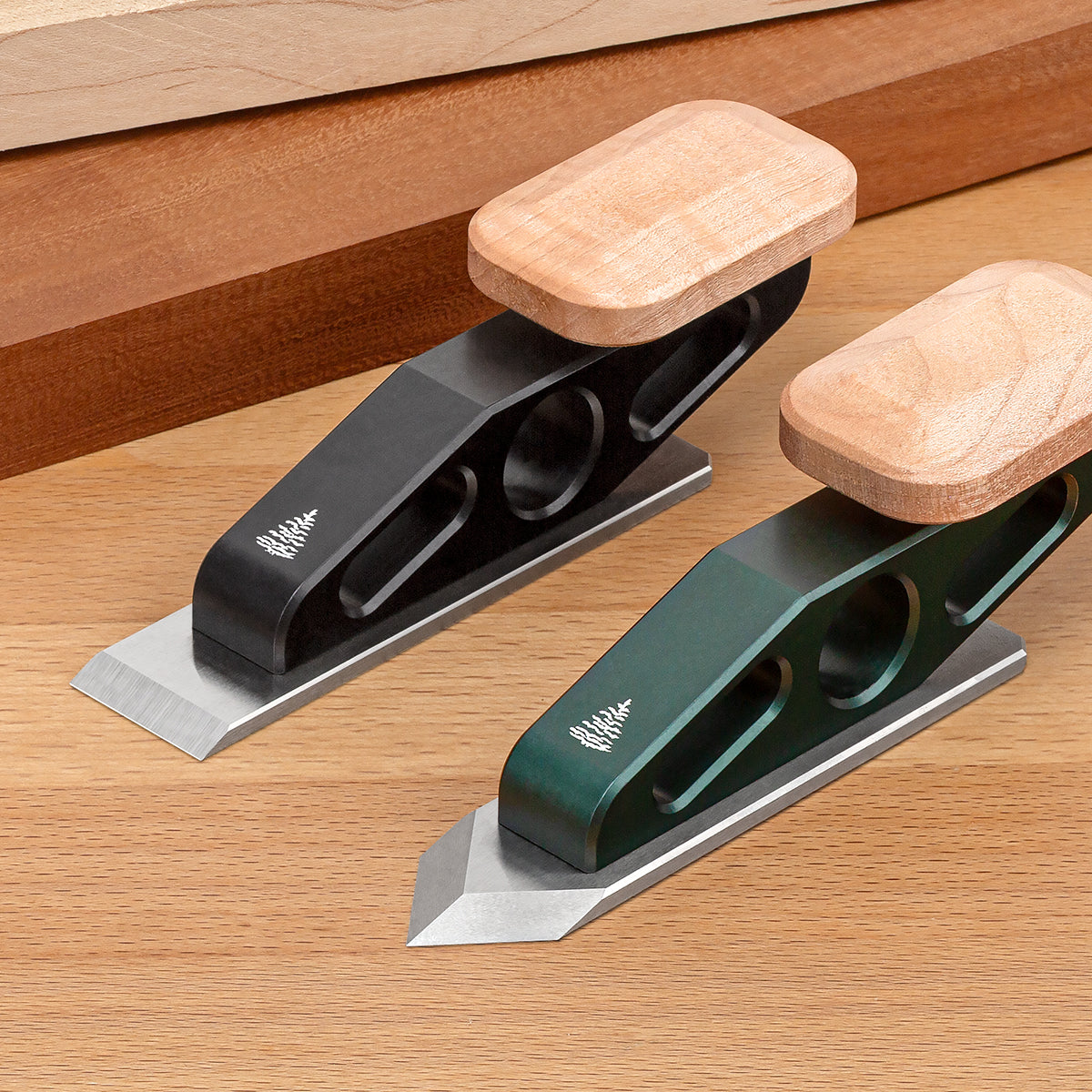  Two Optima Chisel Planes showing the two body colors (black and green) and both available blade irons (Flat and Spearpoint).