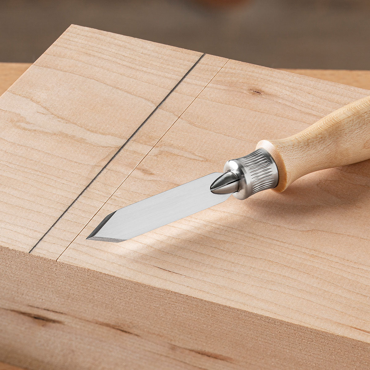 Closeup of the Classic Marking Knife next to a comparison of a physical reference line next to a pencil drawn line.
